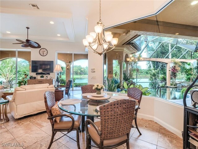 dining room featuring crown molding, a healthy amount of sunlight, ceiling fan with notable chandelier, and a tray ceiling