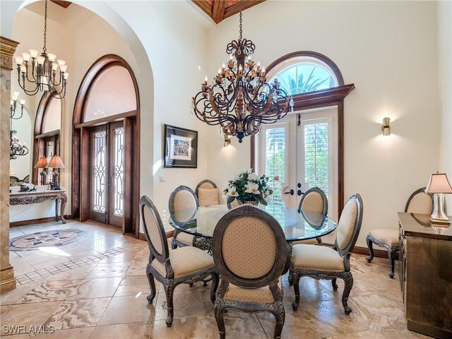 dining room with french doors, a towering ceiling, and an inviting chandelier