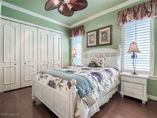 bedroom featuring crown molding, ceiling fan, dark hardwood / wood-style flooring, and a closet