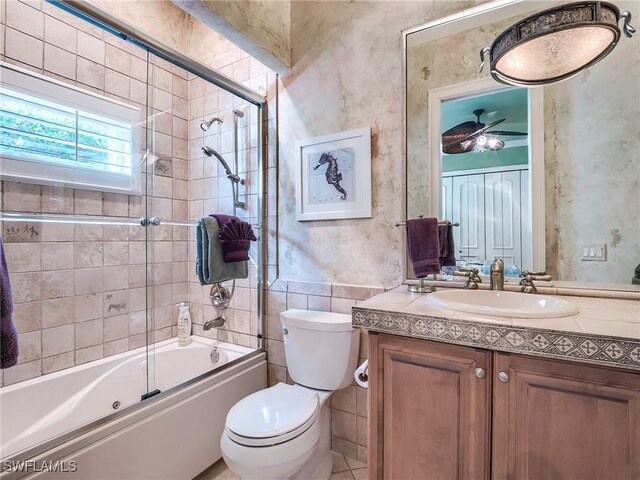 full bathroom featuring vanity, combined bath / shower with glass door, and toilet