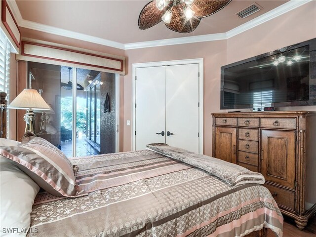 bedroom with wood-type flooring, ornamental molding, and a closet