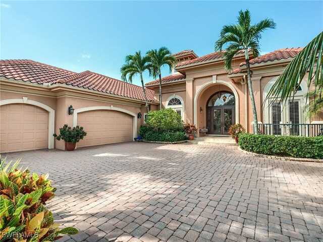 mediterranean / spanish-style home with french doors and a garage