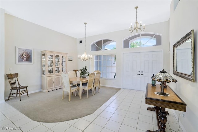 foyer entrance featuring light tile patterned flooring, a high ceiling, a chandelier, and light colored carpet