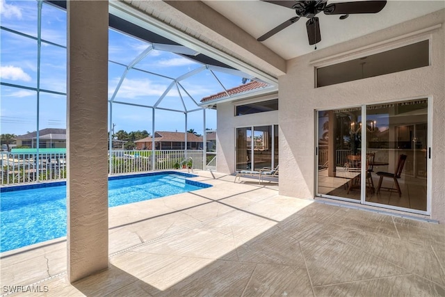 outdoor pool with ceiling fan, a patio area, a lanai, and fence