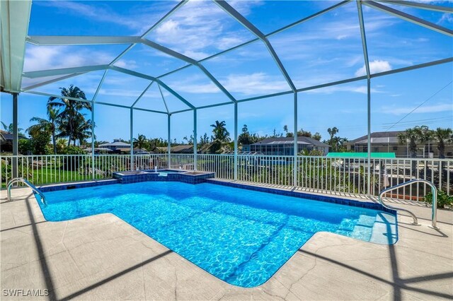 view of swimming pool with an in ground hot tub, a lanai, and a patio area