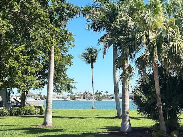 surrounding community featuring a water view and a lawn