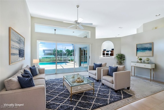 living area featuring ceiling fan and baseboards