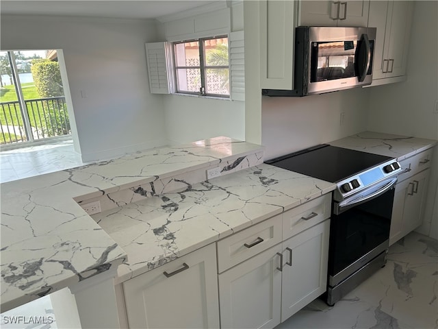 222 Harbour Dr Unit 114, Naples, FL 34103 - kitchen with light stone counters, white cabinetry, stainless steel appliances, and plenty of natural light