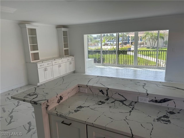 222 Harbour Dr Unit 114, Naples, FL 34103 - kitchen with open shelves, light marble finish flooring, white cabinets, crown molding, and light stone counters