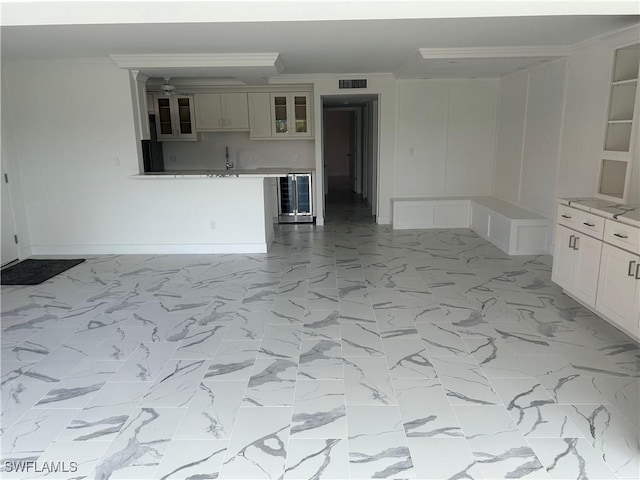222 Harbour Dr Unit 114, Naples, FL 34103 - unfurnished room with beverage cooler, a dry bar, light marble finish flooring, and ornamental molding