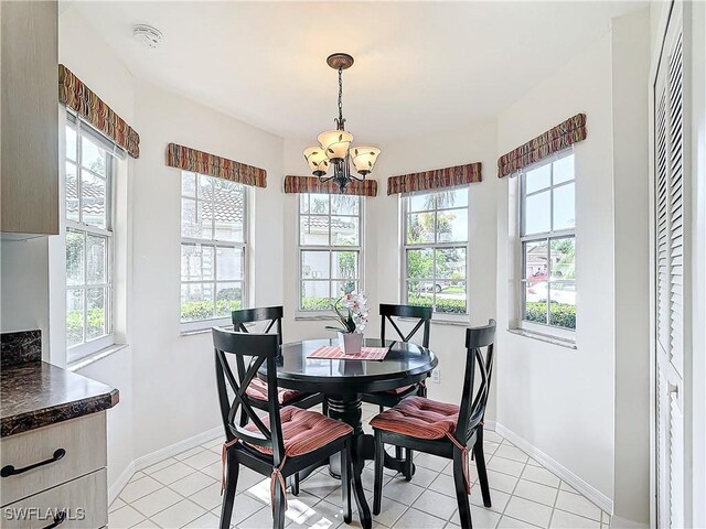 tiled dining area with a wealth of natural light and a notable chandelier