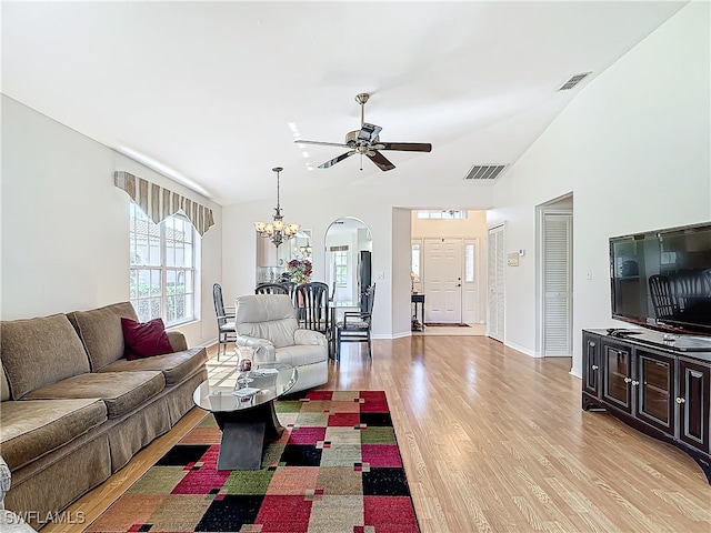 living room featuring ceiling fan with notable chandelier, vaulted ceiling, and light hardwood / wood-style floors