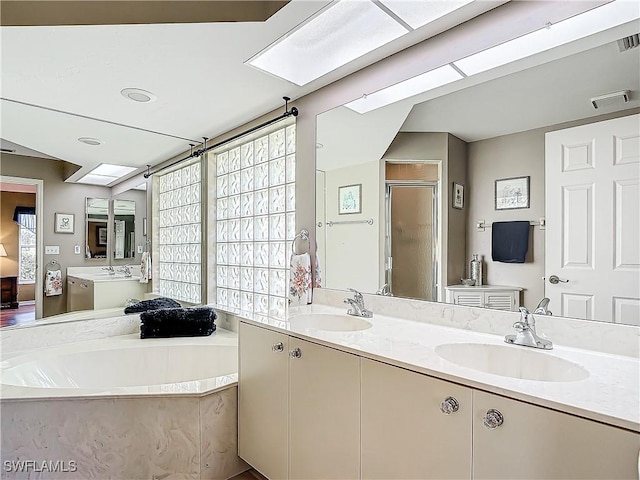 bathroom with a stall shower, a garden tub, a sink, and double vanity