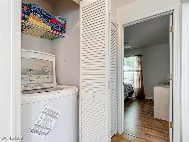 laundry room featuring washer / clothes dryer, laundry area, baseboards, and wood finished floors