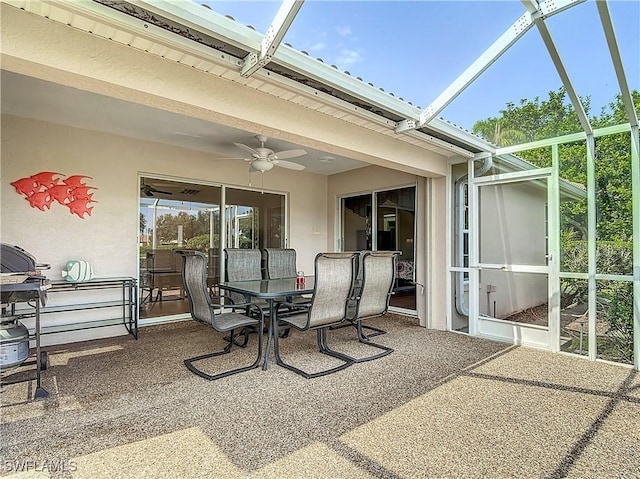 view of patio with outdoor dining area, glass enclosure, and ceiling fan