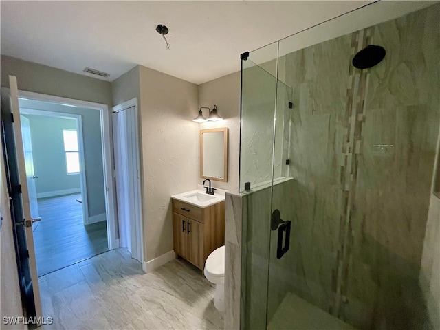 bathroom with vanity, toilet, and a shower with door