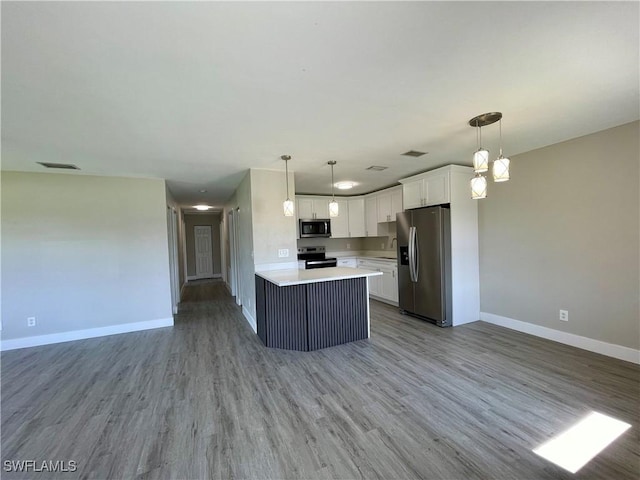 kitchen with white cabinets, decorative light fixtures, light wood-type flooring, and appliances with stainless steel finishes