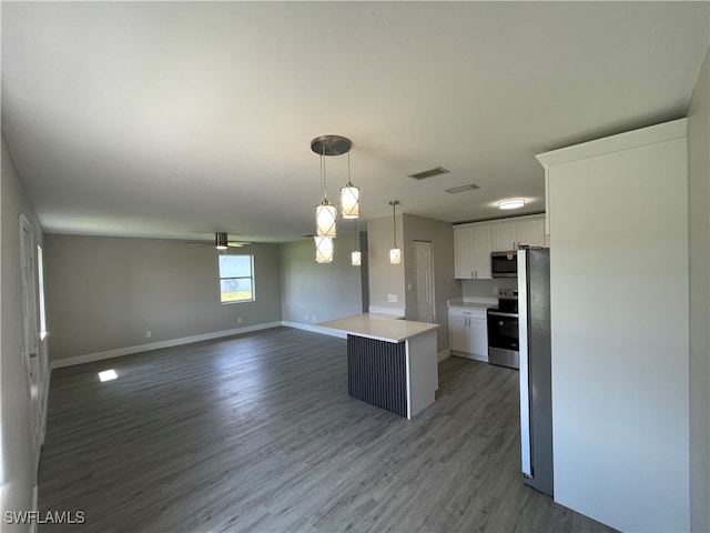 kitchen featuring ceiling fan, hanging light fixtures, stainless steel appliances, a kitchen island, and white cabinets