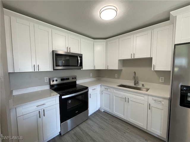 kitchen featuring sink, white cabinets, and appliances with stainless steel finishes