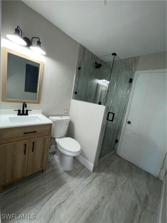 bathroom with vanity, a shower with shower door, and toilet