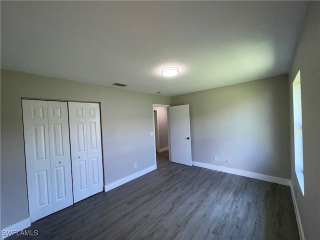 unfurnished bedroom featuring dark hardwood / wood-style flooring and a closet