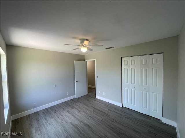 unfurnished bedroom featuring ceiling fan, dark hardwood / wood-style floors, and a closet