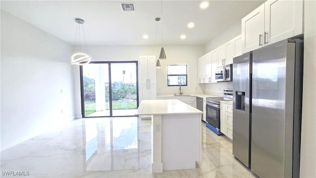 kitchen with appliances with stainless steel finishes, a center island, pendant lighting, white cabinets, and sink