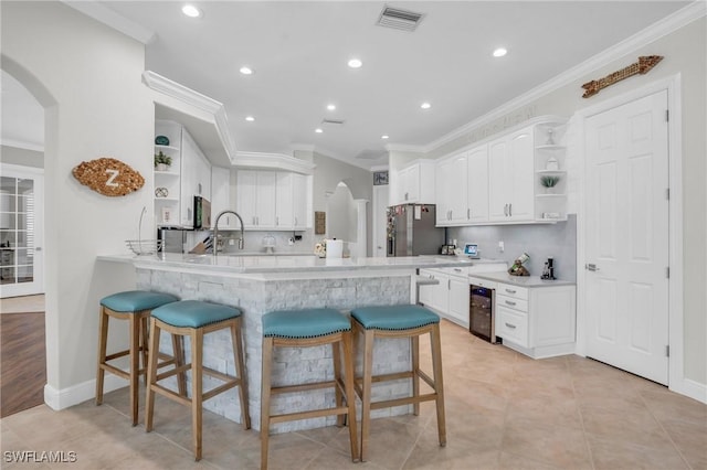 kitchen with light countertops, white cabinets, stainless steel fridge, and open shelves