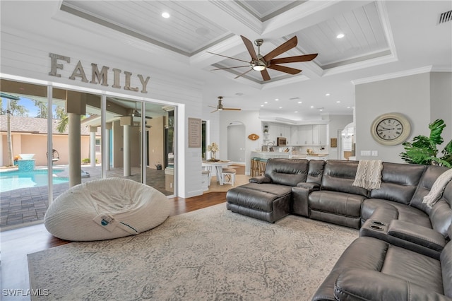 living room with ornamental molding, beam ceiling, light hardwood / wood-style floors, coffered ceiling, and ceiling fan