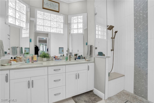 bathroom featuring a tile shower, tile patterned flooring, and a healthy amount of sunlight