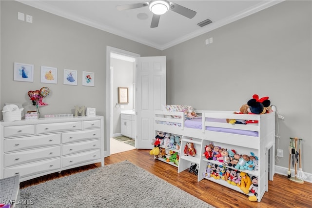 bedroom featuring ceiling fan, crown molding, wood-type flooring, and ensuite bath