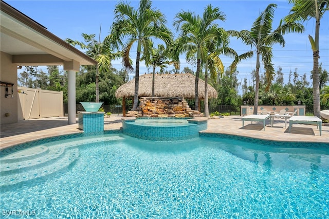 view of swimming pool featuring a patio area and an in ground hot tub