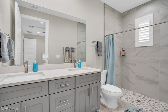 bathroom with toilet, dual bowl vanity, curtained shower, and tile patterned floors