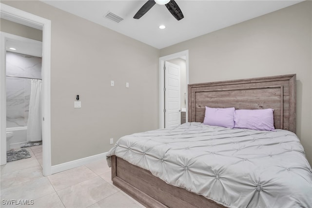 bedroom featuring ceiling fan, light tile patterned floors, and ensuite bath