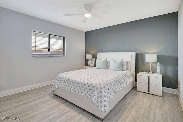 bedroom featuring wood finished floors, a ceiling fan, and baseboards