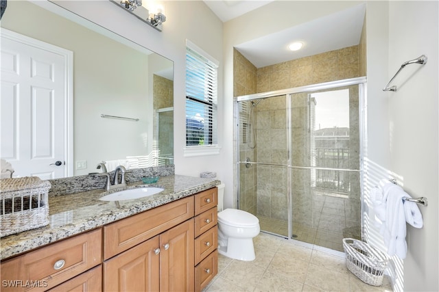 bathroom featuring vanity, walk in shower, toilet, and tile patterned flooring