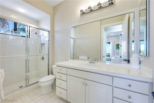 bathroom with an enclosed shower, toilet, vanity, and tile patterned flooring