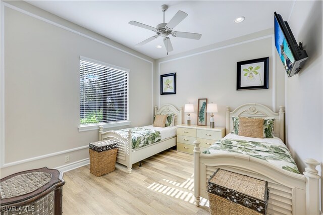 bedroom featuring ceiling fan, light hardwood / wood-style floors, and crown molding