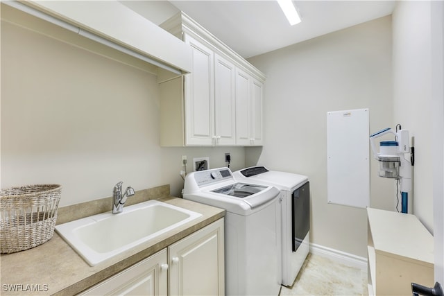 laundry room with independent washer and dryer, light tile patterned floors, sink, and cabinets