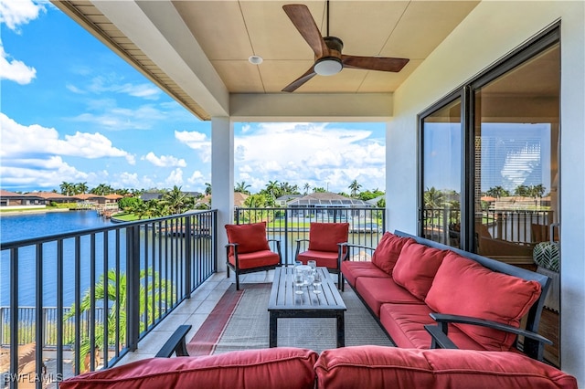 balcony featuring ceiling fan, a water view, and an outdoor living space