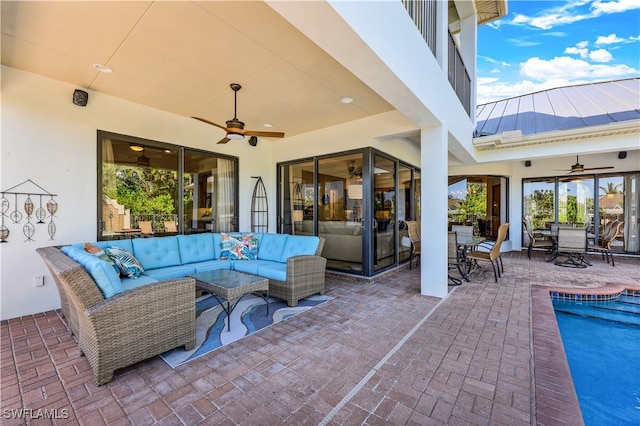 view of patio / terrace featuring a swimming pool, ceiling fan, and an outdoor living space