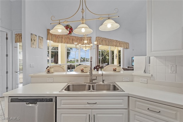 kitchen with lofted ceiling, an inviting chandelier, sink, stainless steel dishwasher, and white cabinetry