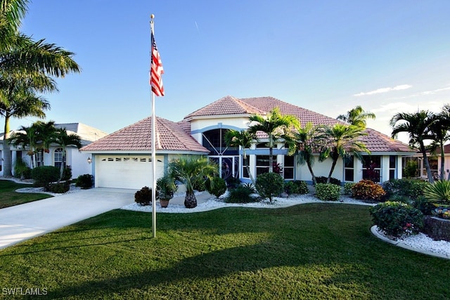 mediterranean / spanish home with a garage and a front lawn