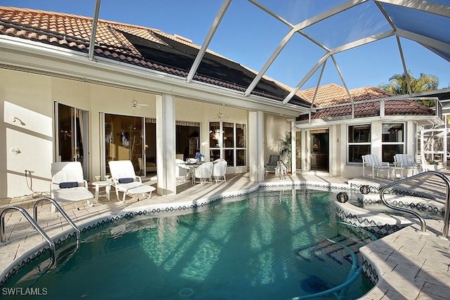 view of swimming pool featuring glass enclosure and a patio area