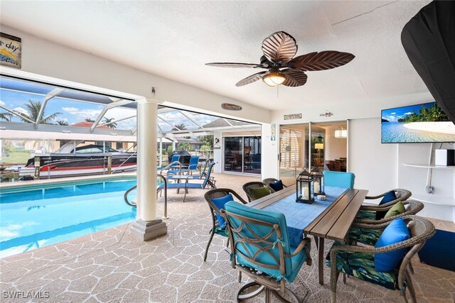 view of swimming pool with ceiling fan, a patio, and a lanai