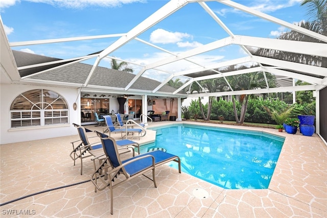 view of pool featuring glass enclosure and a patio area