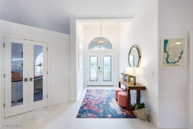 foyer with light tile patterned flooring and french doors