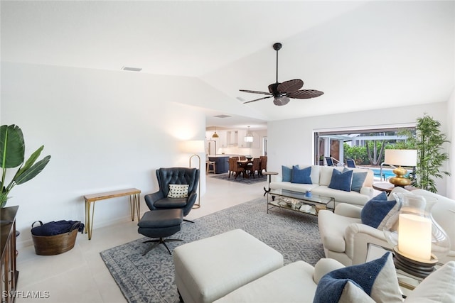 living room with ceiling fan, vaulted ceiling, and light tile patterned flooring