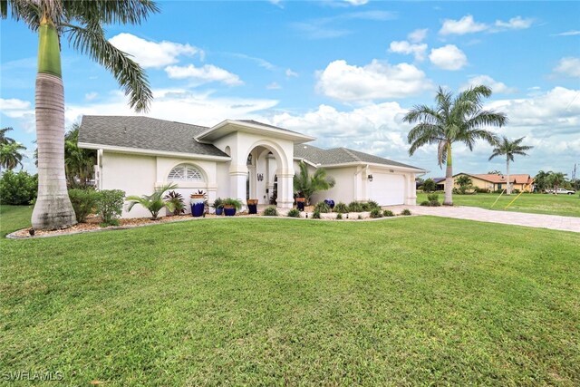 mediterranean / spanish home with a garage and a front lawn