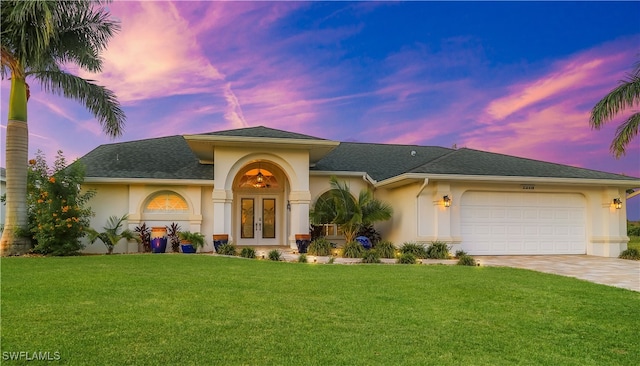 mediterranean / spanish-style home with a garage and a lawn